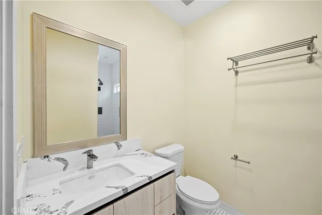 a bathroom with a granite countertop sink toilet and shower