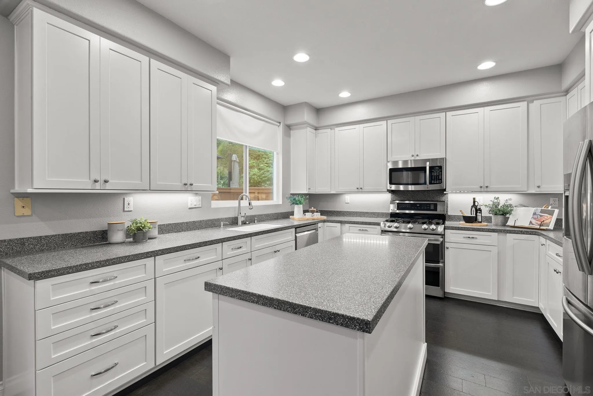 735 River Rock Road Chula Vista, CA 91914 - Photo 15 of 53 a kitchen with stainless steel appliances granite countertop a sink dishwasher a stove and a microwave oven with cabinets
