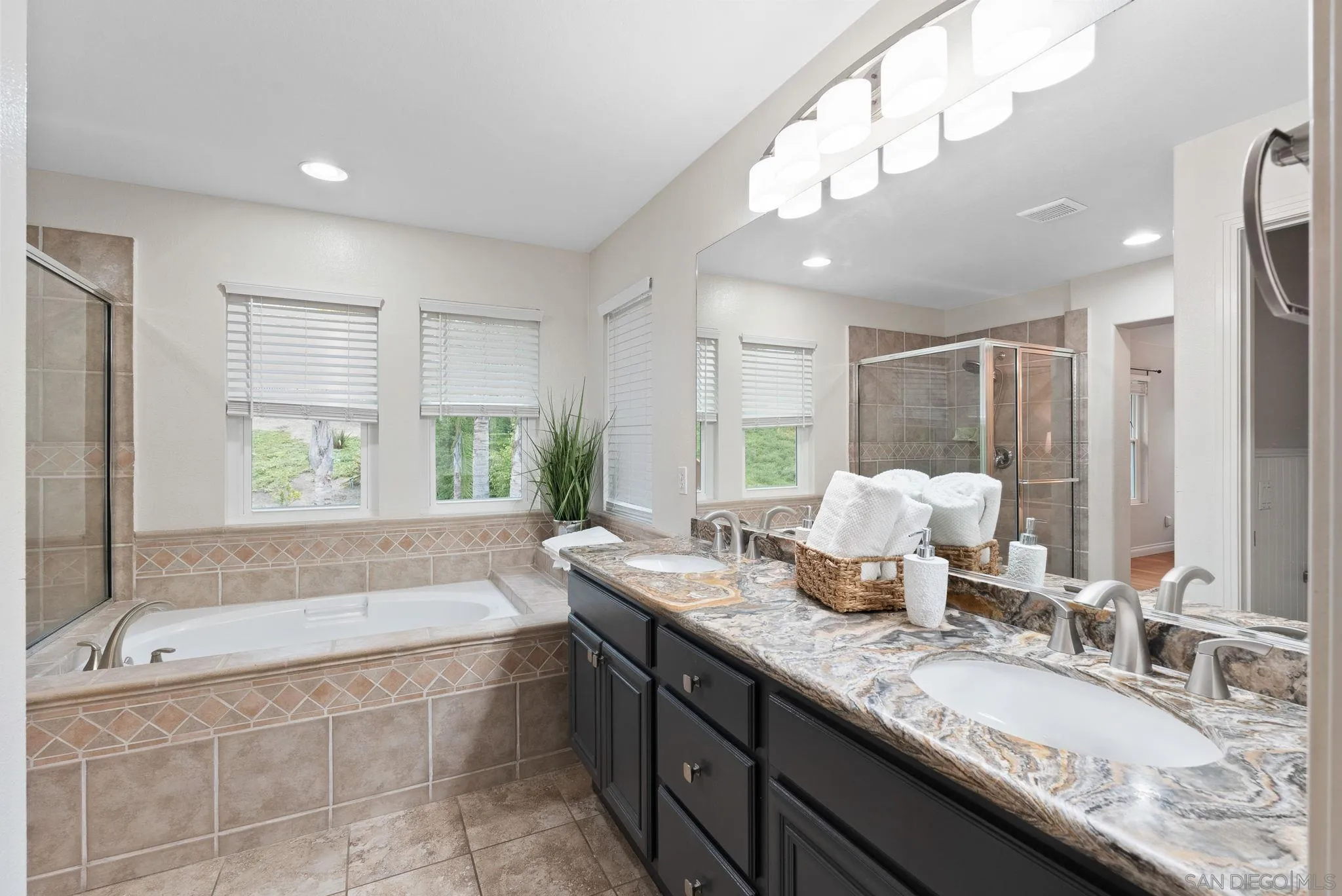 735 River Rock Road Chula Vista, CA 91914 - Photo 23 of 53 a bathroom with a granite countertop bathtub sink vanity and mirror