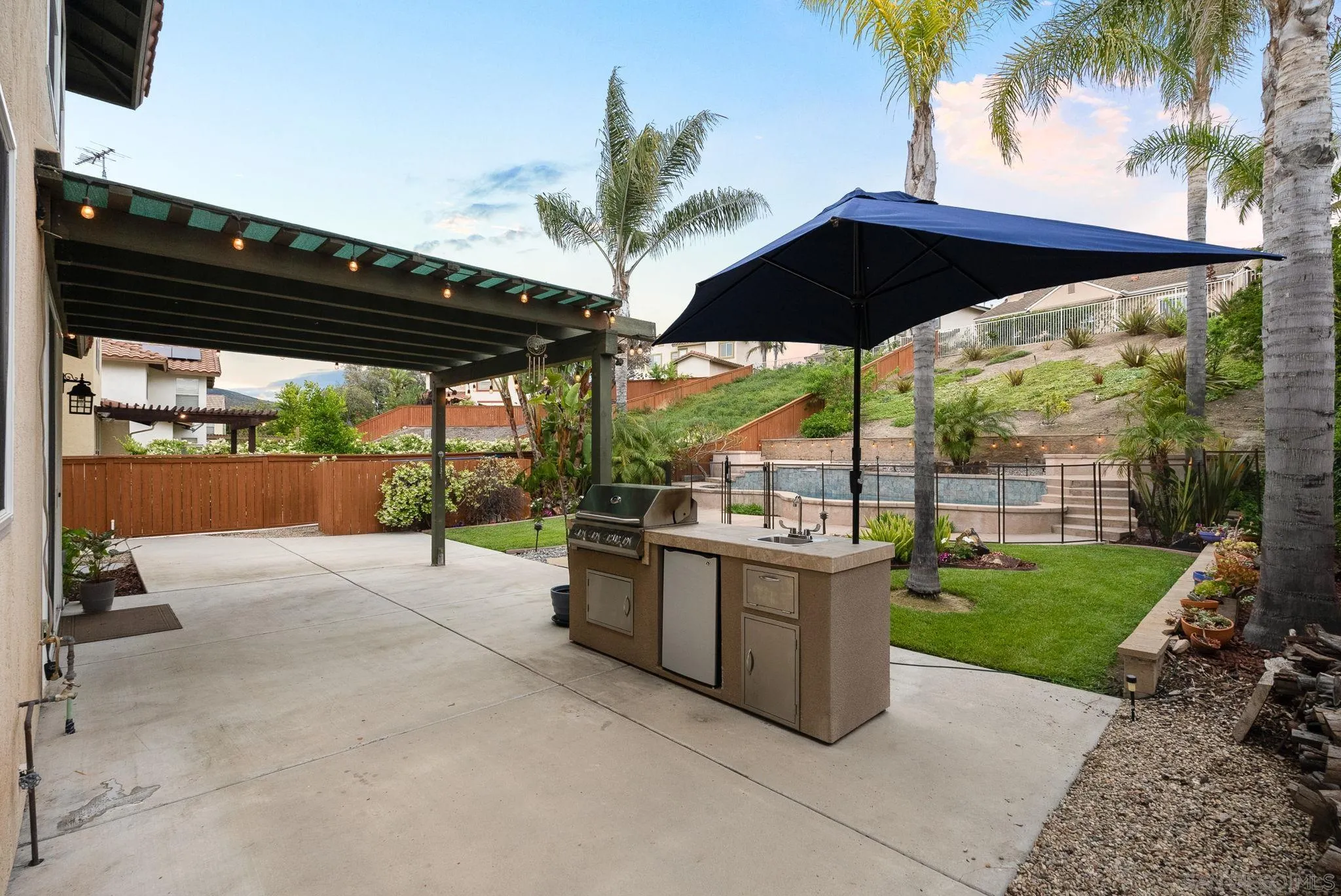 735 River Rock Road Chula Vista, CA 91914 - Photo 45 of 53 a view of a patio with a table and chairs under an umbrella with a tub