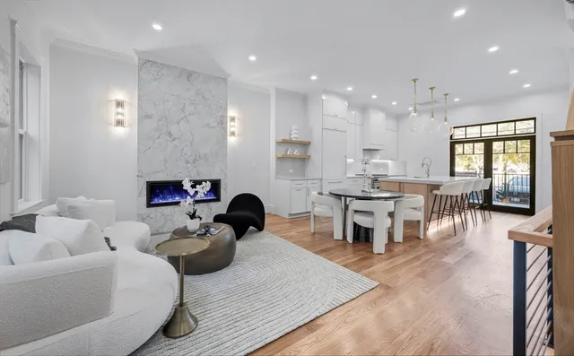 a living room with furniture kitchen view and a wooden floor