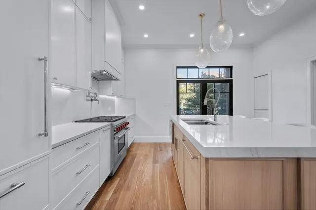 a large white kitchen with a large window