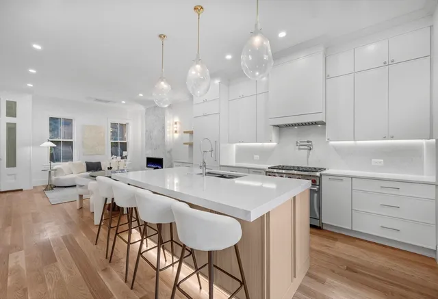 a large kitchen with kitchen island a island a stove a table and chairs in it