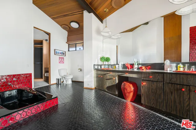 a living room with stainless steel appliances kitchen island granite countertop a rug stove and white cabinets