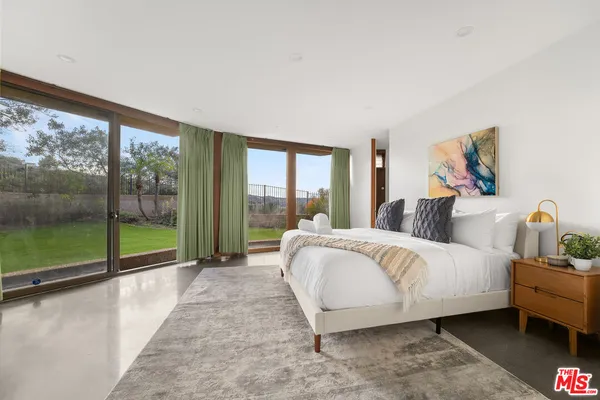 a bed sitting in a bedroom next to a large window