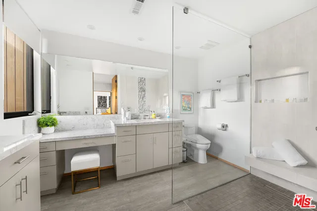 a bathroom with a granite countertop sink a toilet and a shower