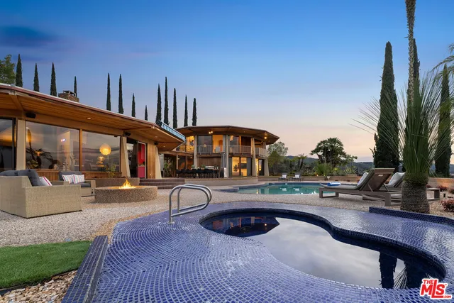 a swimming pool with outdoor seating and yard