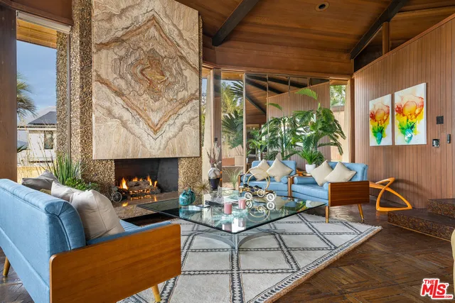 a living room with furniture fireplace and a large window