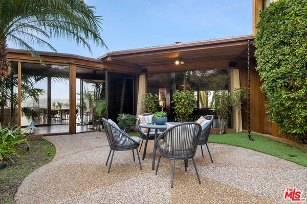 a view of a patio with table and chairs and potted plants