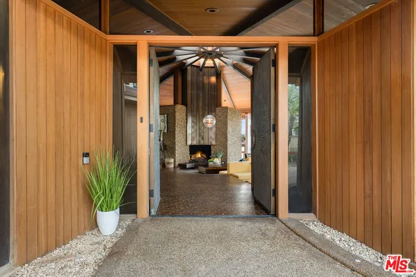 a view of a hallway with potted plants in front of door