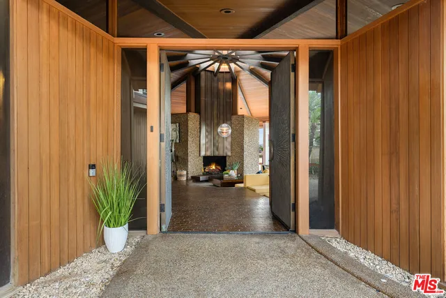 a view of a hallway with potted plants in front of door