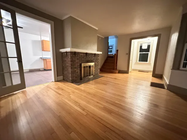 a view of a livingroom with wooden floor and a fireplace