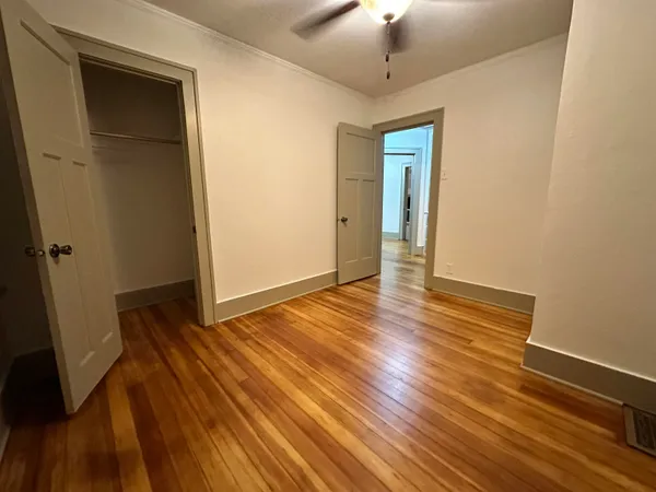 a view of an empty room with wooden floor