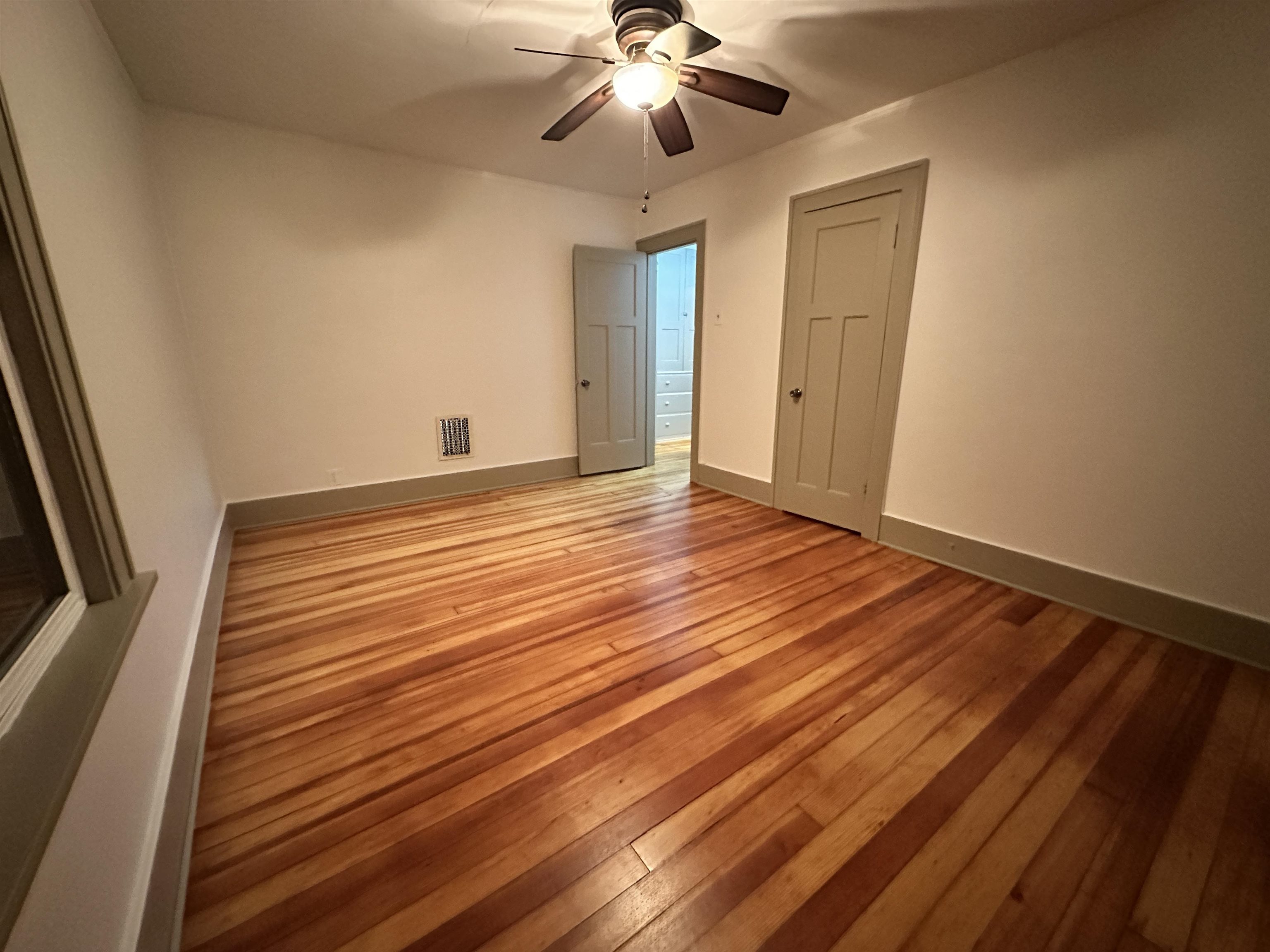 816 South Harlem Avenue Freeport, IL 61032 - Photo 27 of 33 a view of an empty room with wooden floor and a ceiling fan
