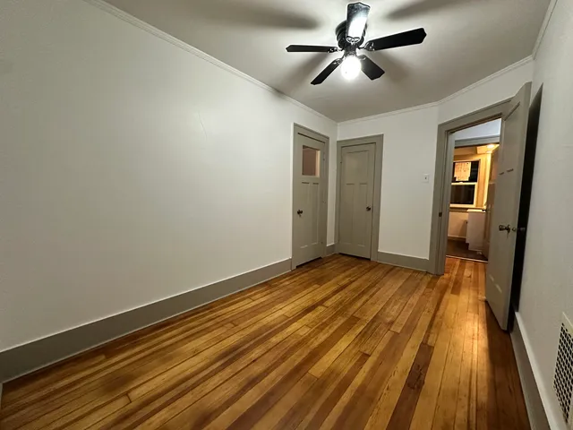 a view of empty room with wooden floor