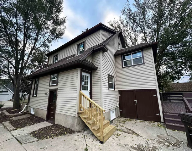 a front view of a house with a tree