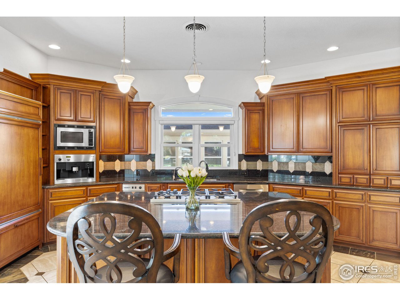 2210 Meadow Avenue Boulder, CO 80304 - Photo 12 of 40 a kitchen with stainless steel appliances kitchen island granite countertop a sink a stove a oven a dining table and chairs