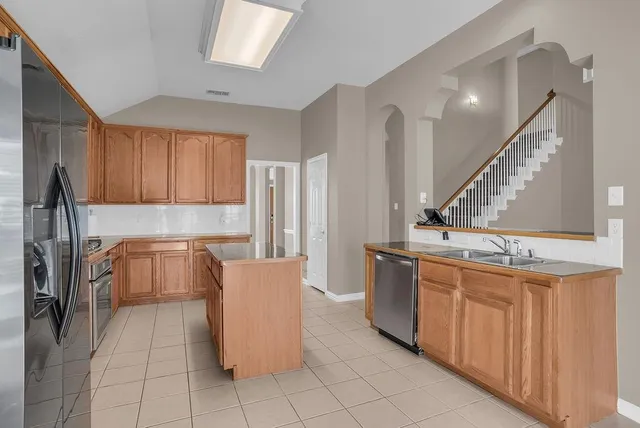 a kitchen with a stove a sink dishwasher and a refrigerator