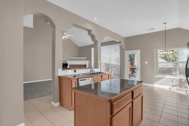 a kitchen with granite countertop a refrigerator and a sink