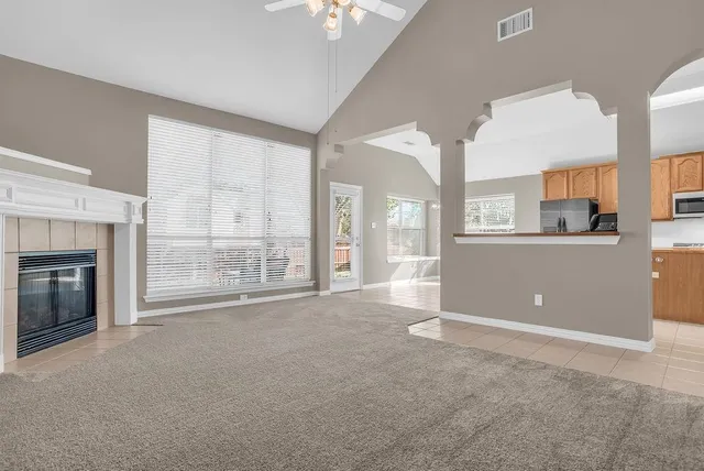 a view of an empty room with a fireplace and a window