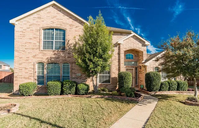 a view of house with yard and tree in front of it