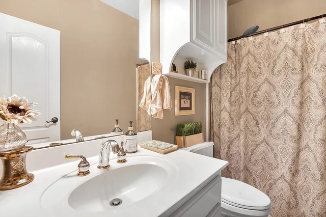 a bedroom with a bed and a mirror on the dresser