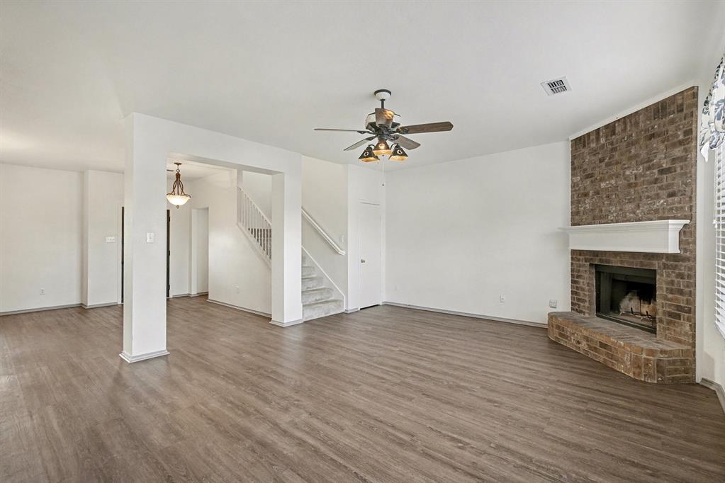 415 Hidden Ridge Drive Burleson, TX 76028 - Photo 14 of 38 a view of an empty room with wooden floor a fireplace and a window