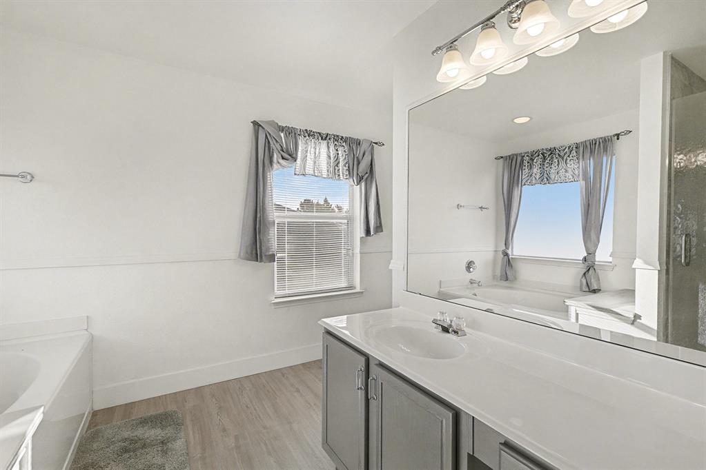 415 Hidden Ridge Drive Burleson, TX 76028 - Photo 22 of 38 a bathroom with a sink a vanity and a large mirror