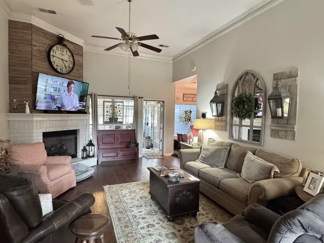 a living room with furniture a flat screen tv and a fireplace