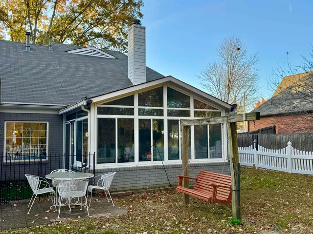 a view of an house with backyard and sitting area
