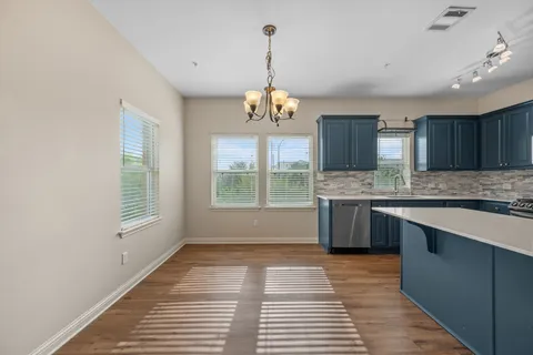 a kitchen with stainless steel appliances granite countertop a stove a sink dishwasher and a wooden cabinets