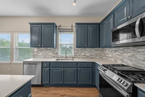 a kitchen with stainless steel appliances a stove sink and cabinets