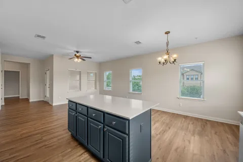 a kitchen with a wooden floor and chandelier