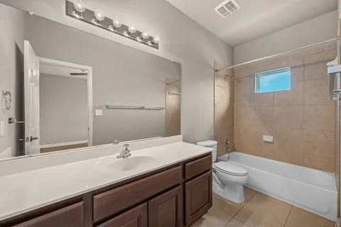 a bathroom with a granite countertop sink a toilet a mirror and shower