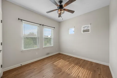 an empty room with a window and a ceiling fan