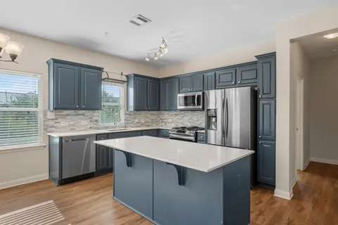 a kitchen with stainless steel appliances a sink stove and refrigerator