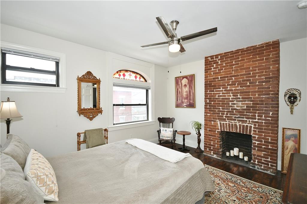 149 Home Street Pittsburgh, PA 15201 - Photo 3 of 14 a bed room with a bed a fireplace and a window