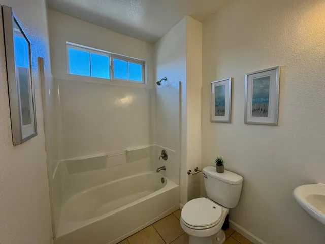 a bedroom with a bed and painting on the wall