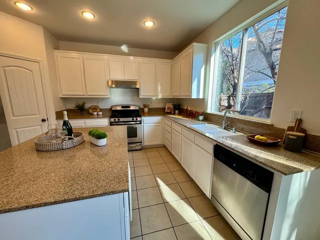 a kitchen with sink a stove and cabinets