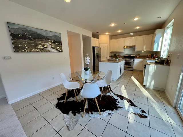 a kitchen with stainless steel appliances kitchen island granite countertop a refrigerator and a stove top oven