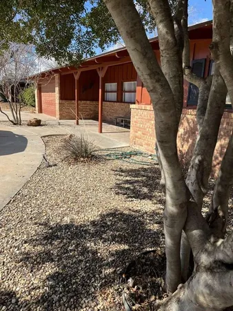 a front view of a house with a yard covered with snow