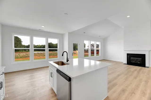 a kitchen with stainless steel appliances granite countertop a sink and a large window