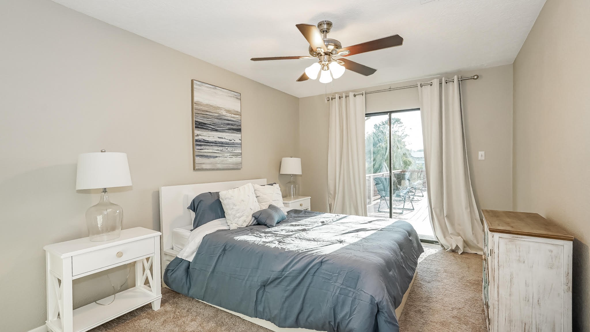 129 Capetown Conroe, TX 77356 - Photo 13 of 35 The second bedroom has carpet floors, a ceiling fan and sliding glass doors to access the patio area.