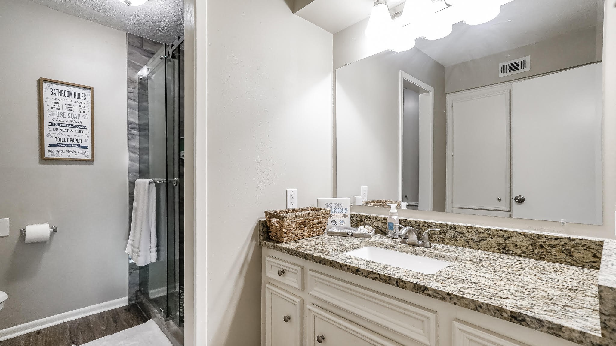 129 Capetown Conroe, TX 77356 - Photo 15 of 35 The second and third bedroom share this bathroom which features laminate wood floors, granite counters and a standing shower with tile surround and sliding glass door.