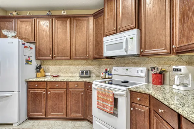 a kitchen with stainless steel appliances granite countertop a refrigerator sink and cabinets