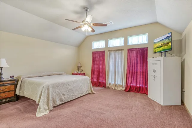 a spacious bedroom with a bed and a chandelier
