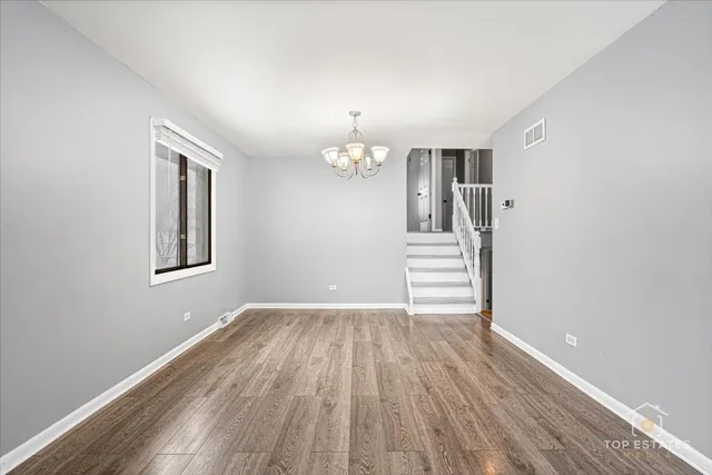 a view of a livingroom with wooden floor and stairs