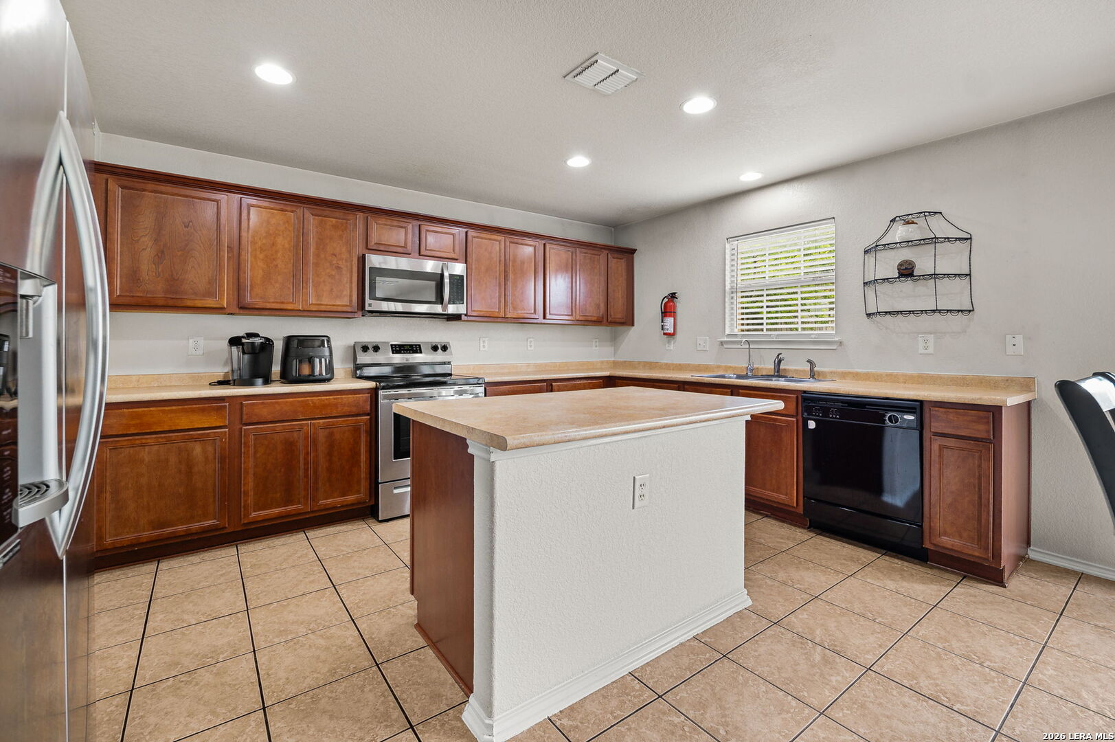 7207 Avery Road Live Oak, TX 78233 - Photo 16 of 32 a kitchen with stainless steel appliances granite countertop a sink counter space cabinets and a stove