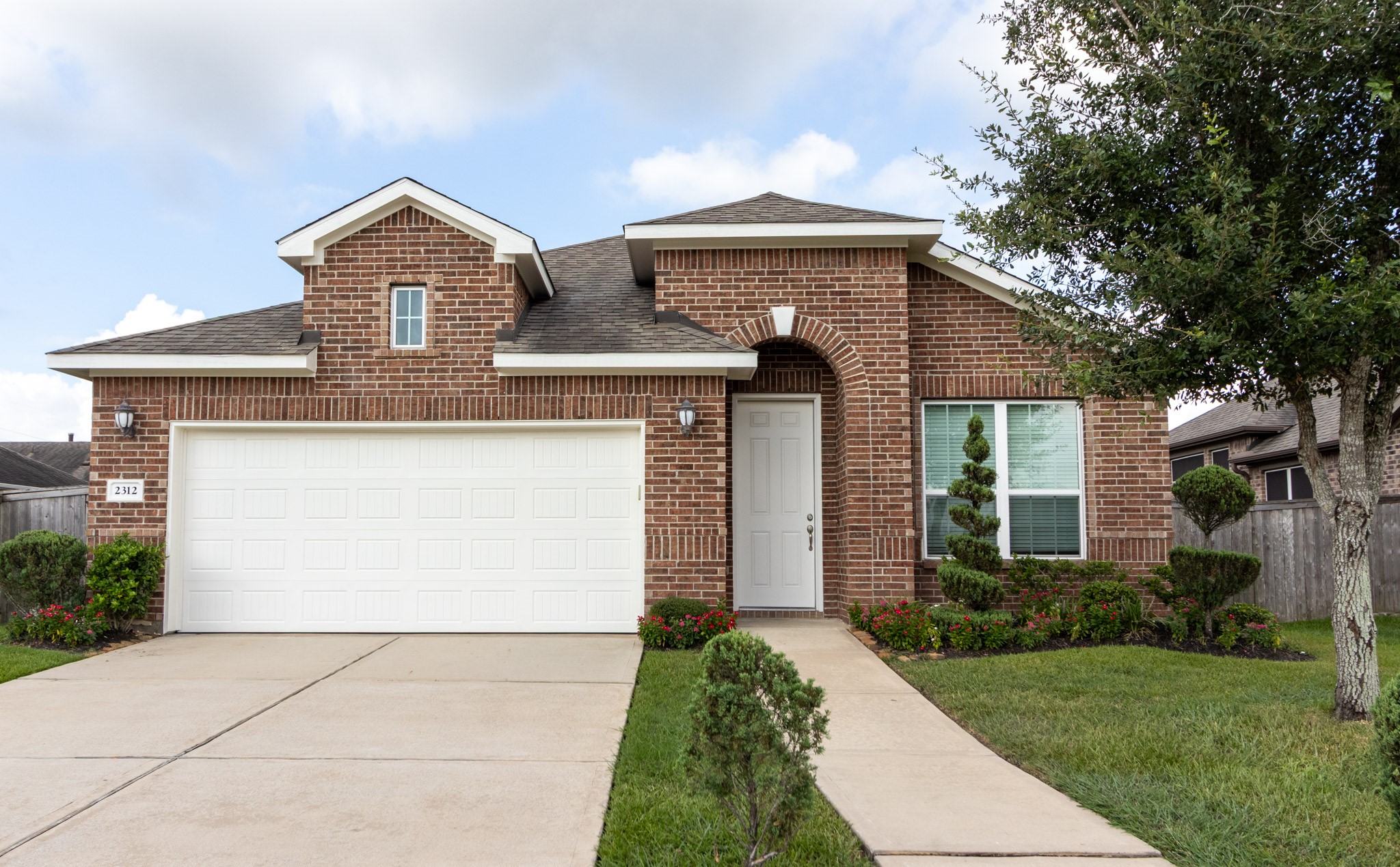 2312 Jessamine Heights Lane Pearland, TX 77089 - Photo 1 of 49 a front view of a house with a garden