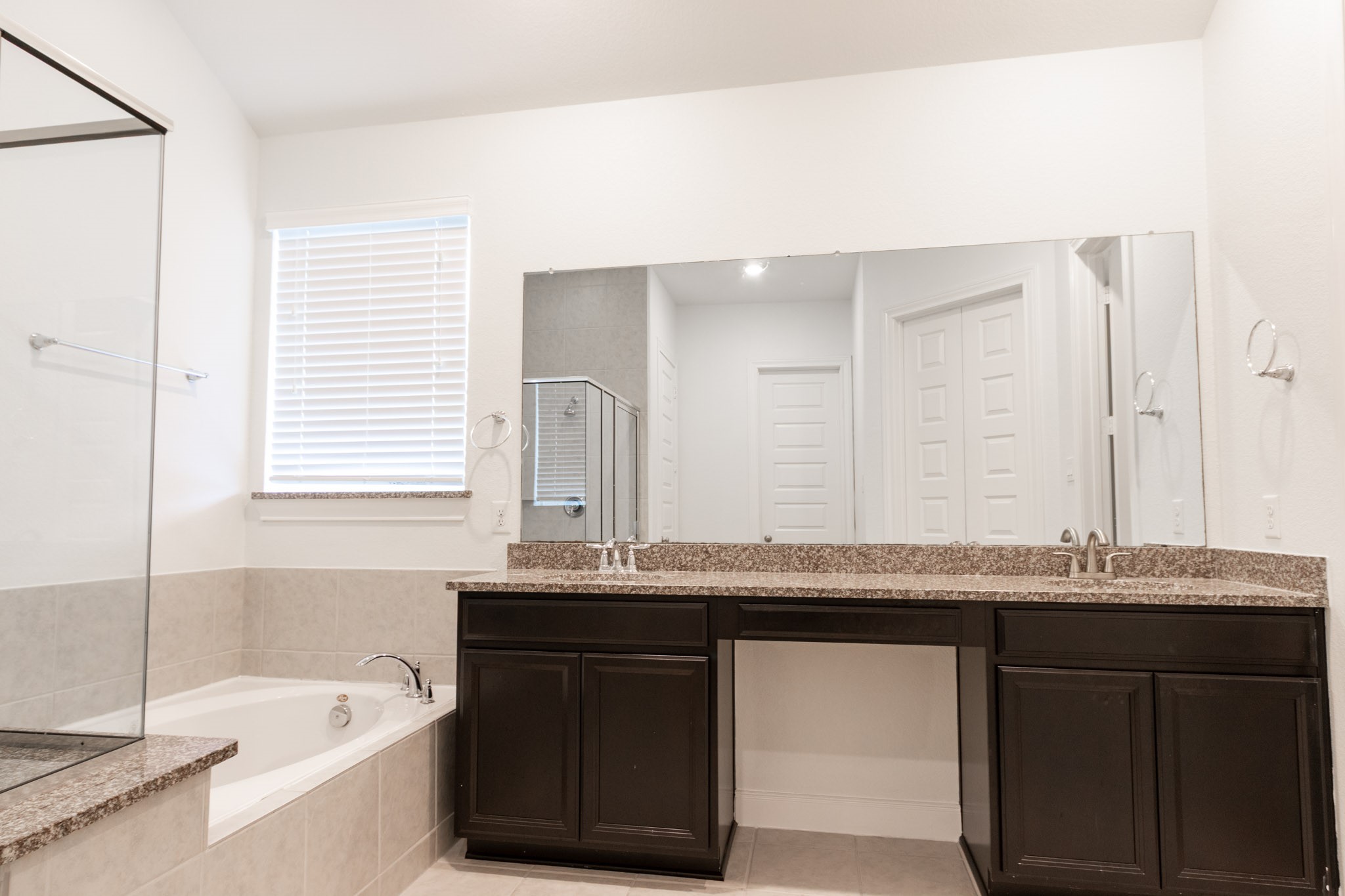 2312 Jessamine Heights Lane Pearland, TX 77089 - Photo 23 of 49 a bathroom with a granite countertop bathtub a sink and a window